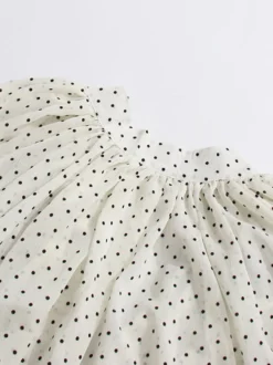 Blouse blanche pour femme col en V manches longues lacées et à volants.
