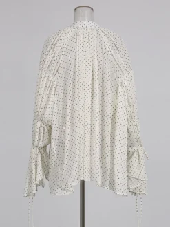 Blouse blanche pour femme col en V manches longues lacées et à volants.
