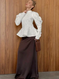Blouse texturée en jacquard à manches bouffantes col montant taille péplum ourlet évasé