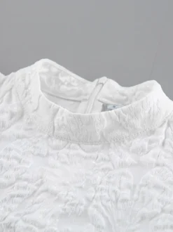 Blouse texturée en jacquard à manches bouffantes col montant taille péplum ourlet évasé