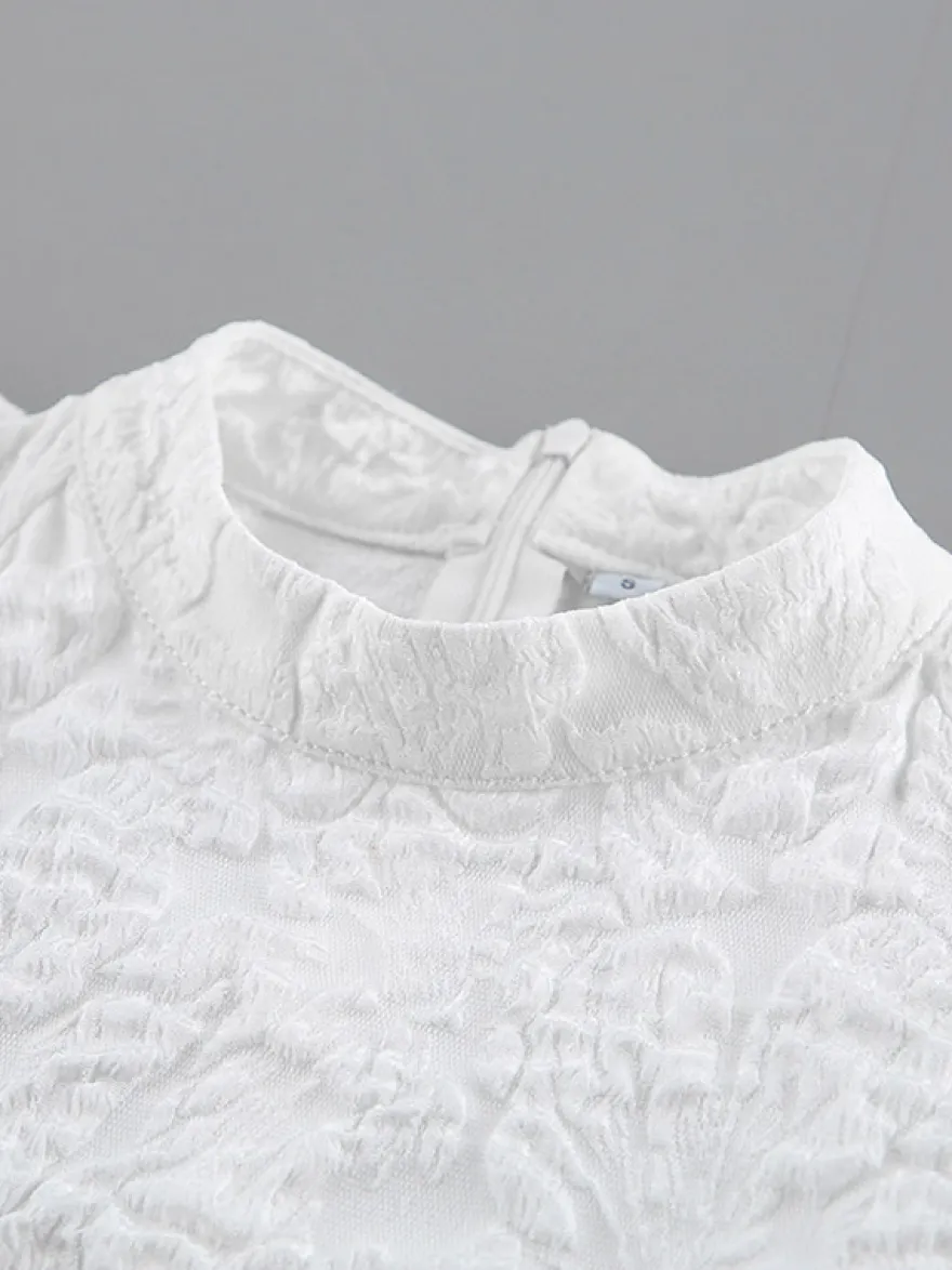 Blouse texturée en jacquard à manches bouffantes col montant taille péplum ourlet évasé
