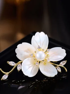 Broche branche de fleur en nacre blanche plaquée or et ornée de zirconiums cubiques