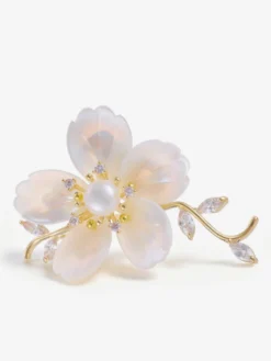 Broche branche de fleur en nacre blanche plaquée or et ornée de zirconiums cubiques