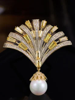 Broche pendentif en forme d'éventail ornée d'un zircon baguette et d'une grande perle.