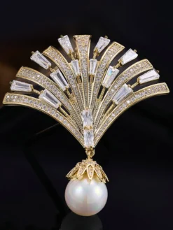 Broche pendentif en forme d'éventail ornée d'un zircon baguette et d'une grande perle.