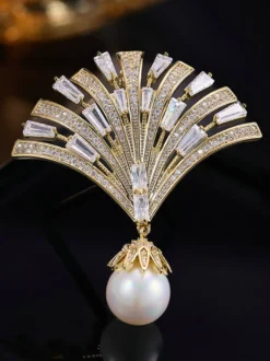Broche pendentif en forme d'éventail ornée d'un zircon baguette et d'une grande perle.