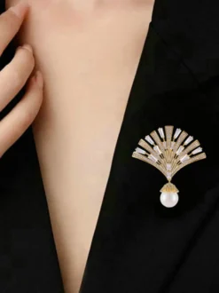 Broche pendentif en forme d'éventail ornée d'un zircon baguette et d'une grande perle.