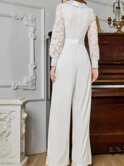 Combinaison blanche à manches longues en dentelle taille haute et jambes larges style nuptial.