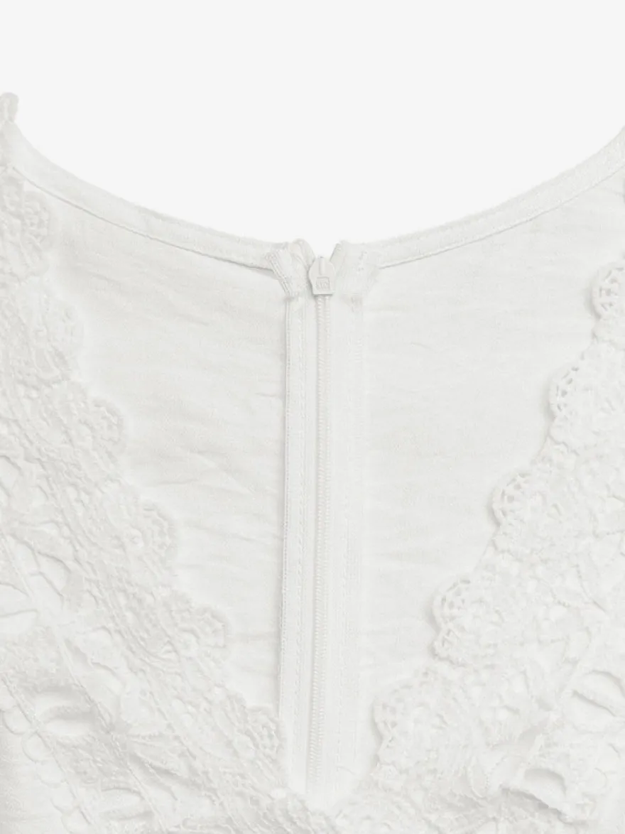 Combinaison bohème blanc cassé texturée col en V manches courtes à volants découpes en dentelle crochetée taille haute jambes larges style playsuit décontracté