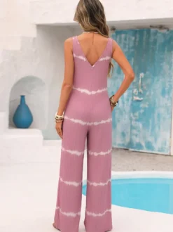 Combinaison rose pâle à imprimé tie-dye horizontal sans manches col V bretelles taille haute jambes larges idéale pour les vacances.