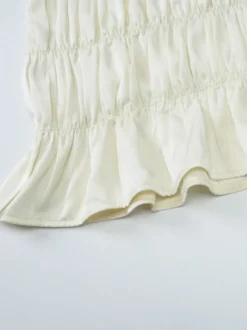 Ensemble deux pièces abricot chic plissé idéal pour les vacances avec bretelles et col à volants jupe sans manches à volants.