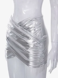 Jupe courte portefeuille argentée métallisée décolleté en V froncé moulante et brillante idéale pour les soirées en boîte.