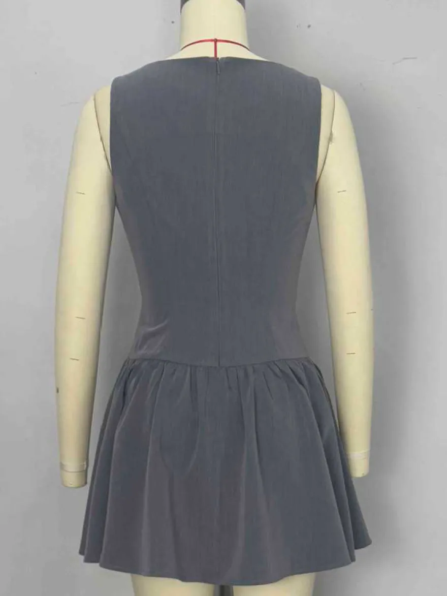 Mini-robe plissée sans manches et boutonnée sur le devant grise été 2026