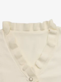 Pull-over décontracté à col en V à volants et boutons nacrés pour femme couleur crème manches longues coupe ajustée.