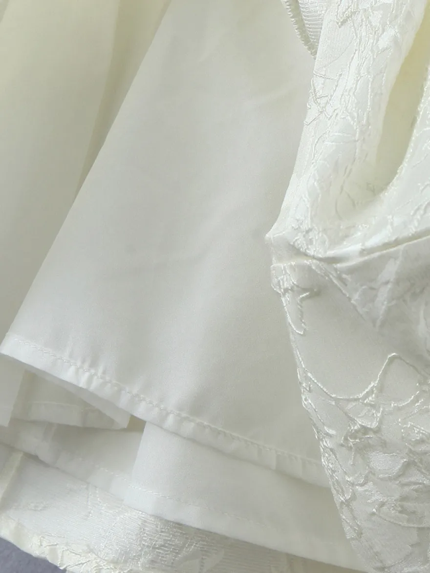 Robe blanche chic à nœuds sculptants et sans manches col carré idéale pour une soirée romantique.