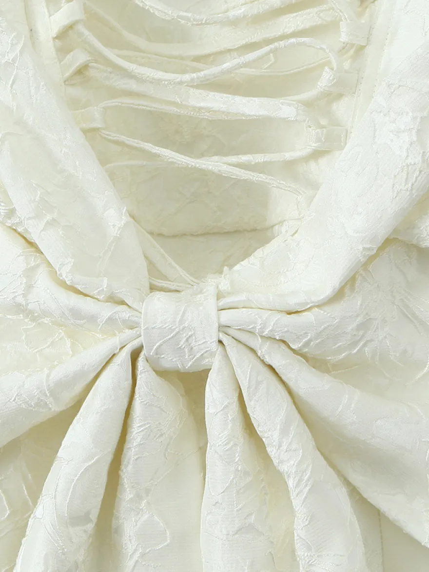 Robe blanche chic à nœuds sculptants et sans manches col carré idéale pour une soirée romantique.
