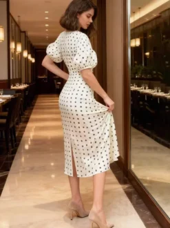 Robe blanche élégante mi-longue en dentelle à pois et col en V idéale pour une soirée romantique.