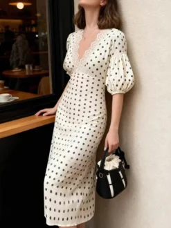 Robe blanche élégante mi-longue en dentelle à pois et col en V idéale pour une soirée romantique.