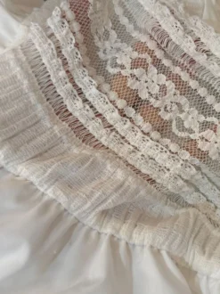 Robe bohème courte trapèze à bretelles fines et dentelle ajourée taille haute et bustier noué.