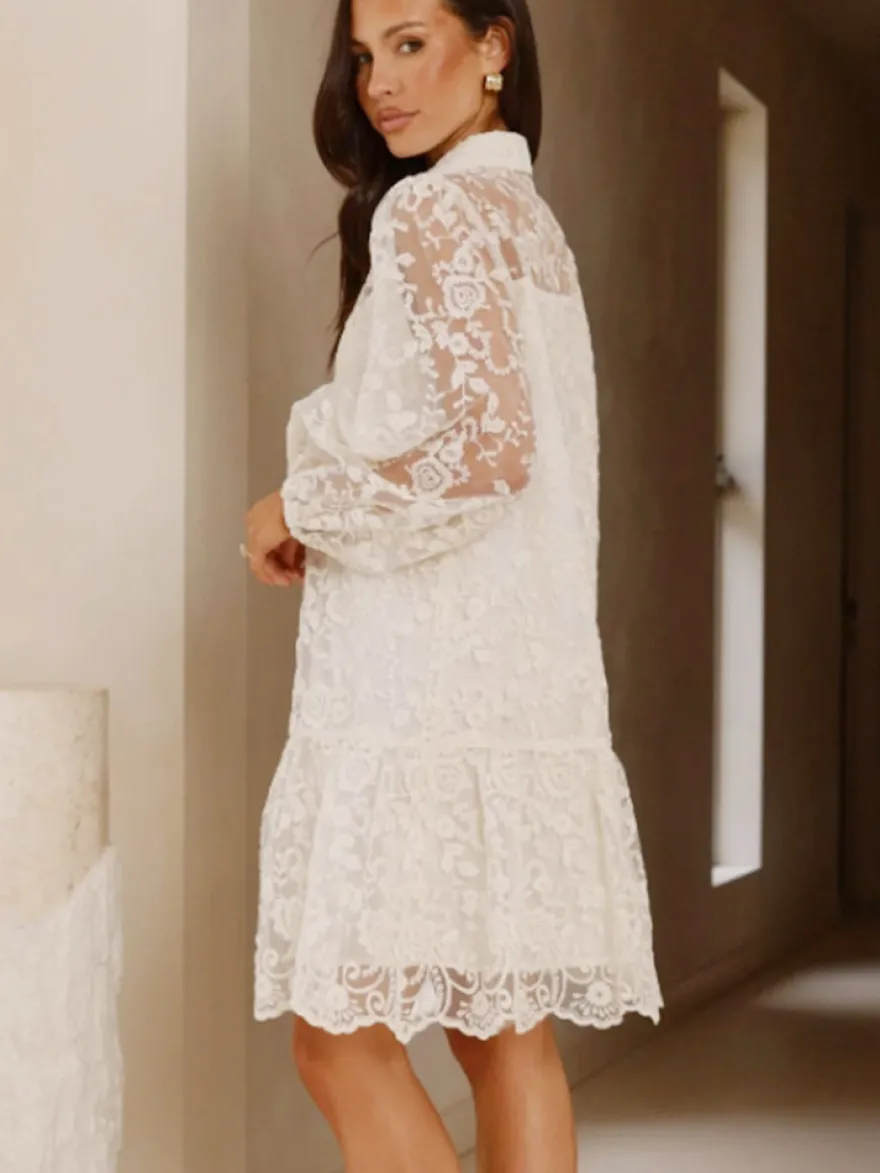 Robe chemise courte écru en dentelle blanche à manches longues et col rabattu manches bouffantes idéale pour tous les jours.