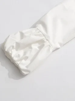 Robe courte blanche boutonnée à manches longues et col rabattu idéale pour tous les jours.