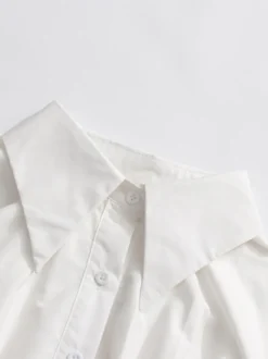 Robe courte blanche boutonnée à manches longues et col rabattu idéale pour tous les jours.