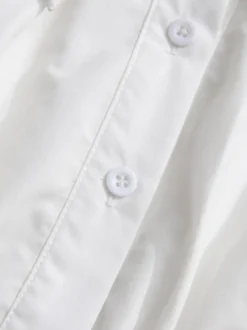 Robe courte blanche boutonnée à manches longues et col rabattu idéale pour tous les jours.