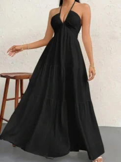 Robe de plage longue maxi fluide à dos nu et col halter en V ornée de volants superposés idéale pour les vacances d'été.