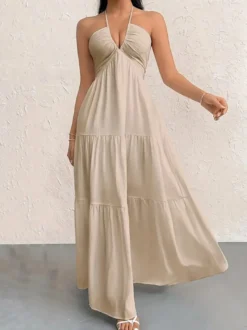 Robe de plage longue maxi fluide à dos nu et col halter en V ornée de volants superposés idéale pour les vacances d'été.