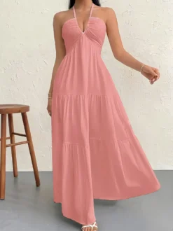 Robe de plage longue maxi fluide à dos nu et col halter en V ornée de volants superposés idéale pour les vacances d'été.