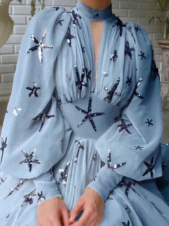Robe de soirée bleu océan à col montant et sequins manches longues bouffantes coupe élégante et semi-formelle.