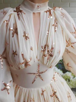 Robe de soirée bleu océan à col montant et sequins manches longues bouffantes coupe élégante et semi-formelle.