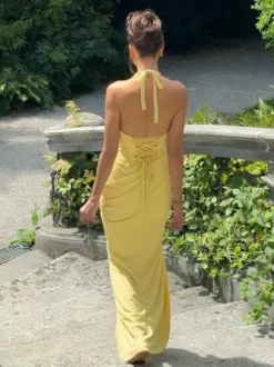 Robe de soirée jaune à col halter et décolleté plongeant style sirène dos lacé et taille froncée