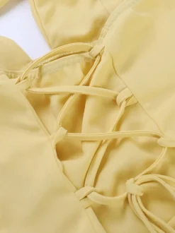 Robe de soirée jaune à col halter et décolleté plongeant style sirène dos lacé et taille froncée