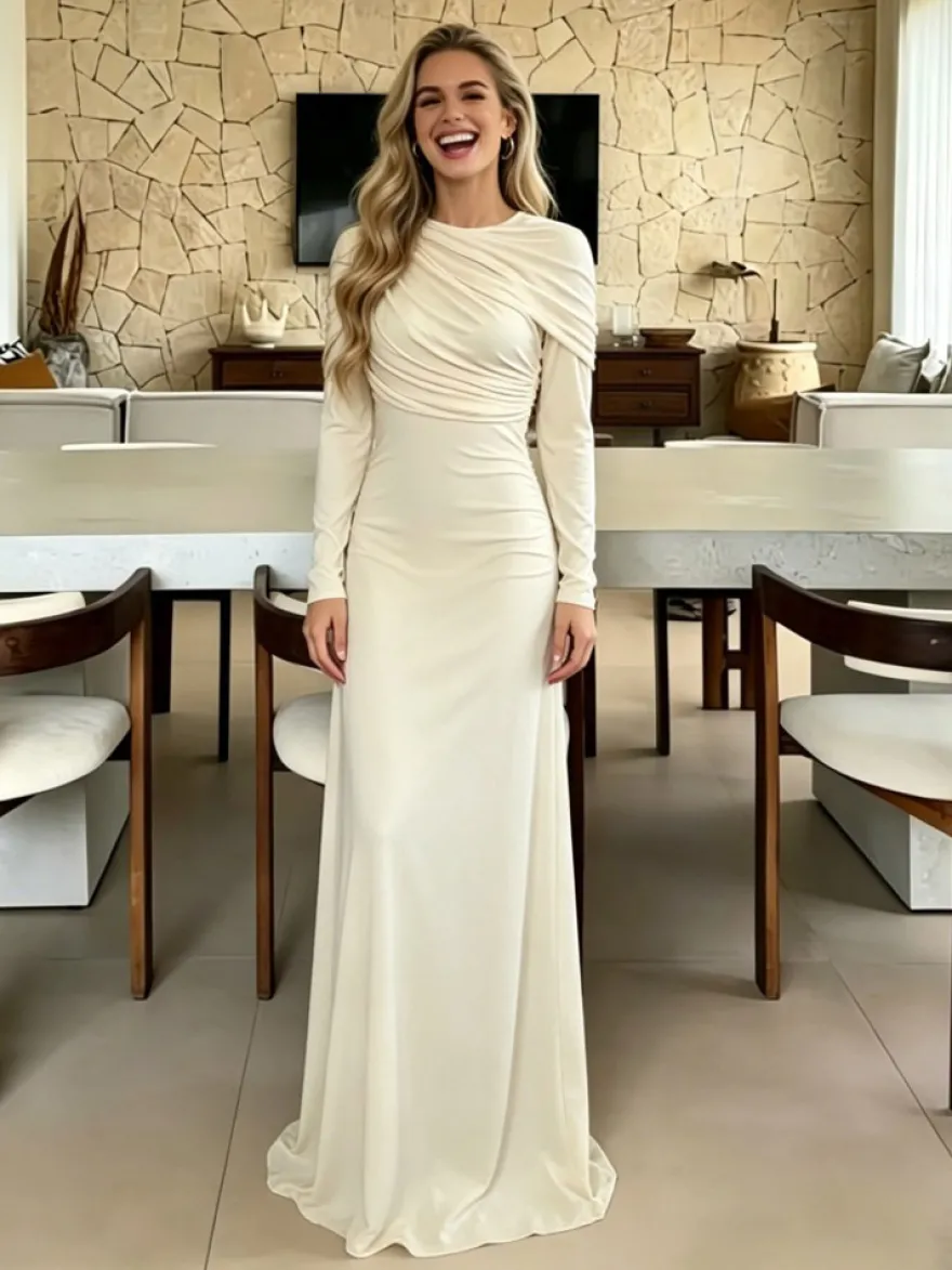 Robe de soirée élégante et moulante couleur crème épaules drapées et manches longues.