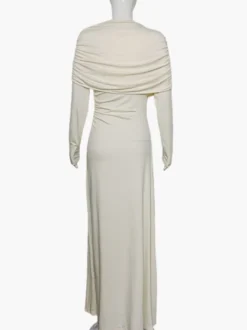 Robe de soirée élégante et moulante couleur crème épaules drapées et manches longues.
