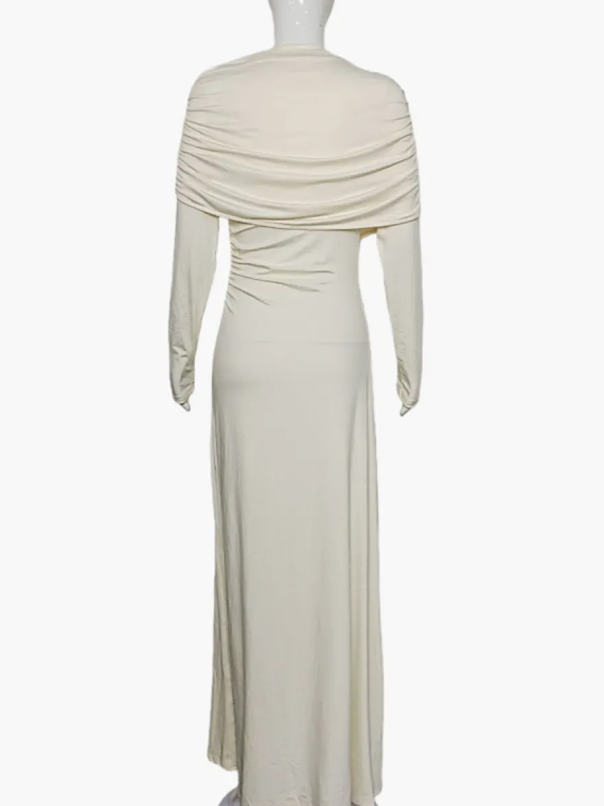 Robe de soirée élégante et moulante couleur crème épaules drapées et manches longues.
