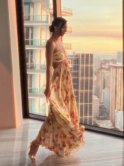 Robe de soirée longue à bretelles spaghetti et dos nu imprimé floral style bohème idéale pour l'été et la plage.