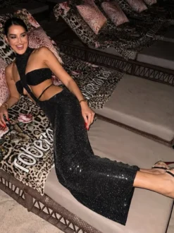 Robe de soirée longue moulante à paillettes col montant et découpes sans manches et taille ajourée.
