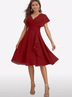 Robe de soirée midi en mousseline à col V manches papillon taille froncée et ourlet à volants.