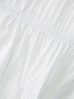 Robe de vacances fluide à volants et smocks épaules dénudées manches à volants idéale pour les vacances d'été.