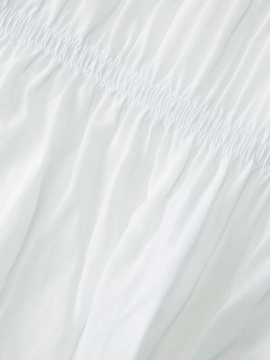 Robe de vacances fluide à volants et smocks épaules dénudées manches à volants idéale pour les vacances d'été.