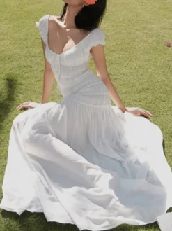 Robe de vacances fluide à volants et smocks épaules dénudées manches à volants idéale pour les vacances d'été.