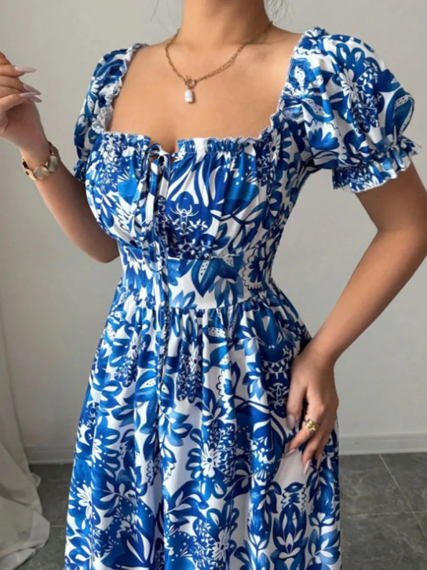 Robe de vacances maxi fleurie à col carré manches bouffantes et nœud sur le devant taille smockée et volants étagés