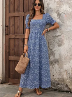 Robe d'été fluide et longue bleu foncé à petites fleurs col carré et manches bouffantes taille élastique.