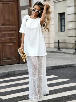 Robe longue blanche élégante en dentelle à manches courtes et col rond idéale pour une soirée romantique.