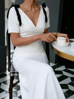 Robe longue blanche élégante à nœuds manches courtes et col en V bicolore idéale pour une soirée romantique.