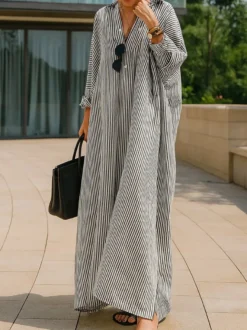 Robe longue chemise oversize à rayures verticales bleues et noires ourlet fendu idéale pour les vacances.