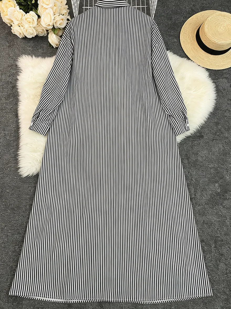 Robe longue chemise oversize à rayures verticales bleues et noires ourlet fendu idéale pour les vacances.