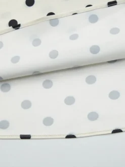 Robe longue crème flatteuse à col en V et pois noirs idéale pour les soirées.